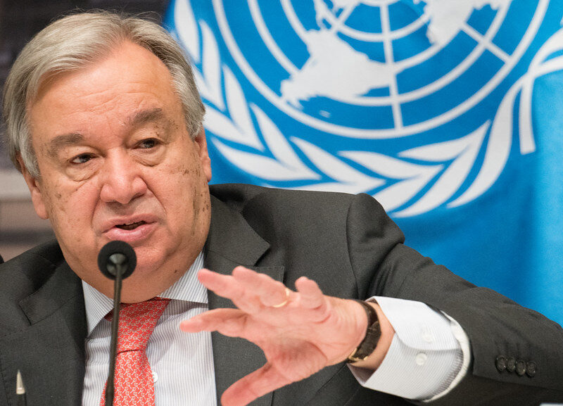 A photo of United Nations Secretary General Antonio Guterres speaking into a microphone.