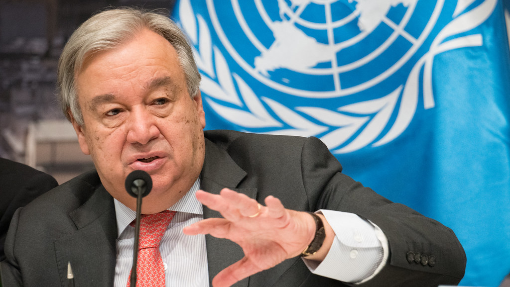 A photo of United Nations Secretary General Antonio Guterres speaking into a microphone.