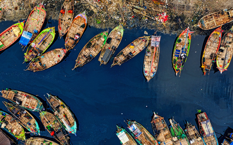 Aerial View of Fishing Boats Docked Along The River.