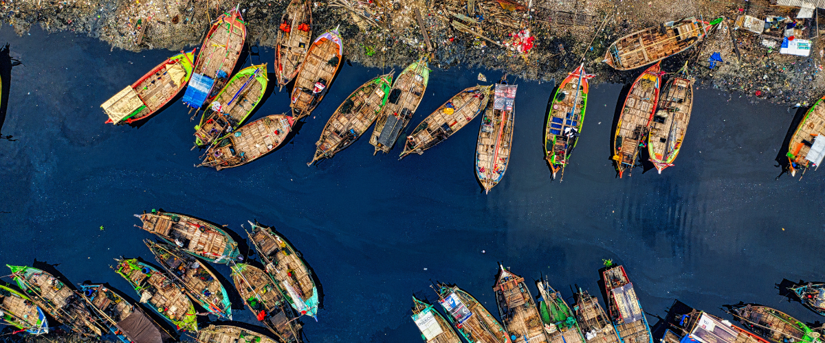 Aerial View of Fishing Boats Docked Along The River.
