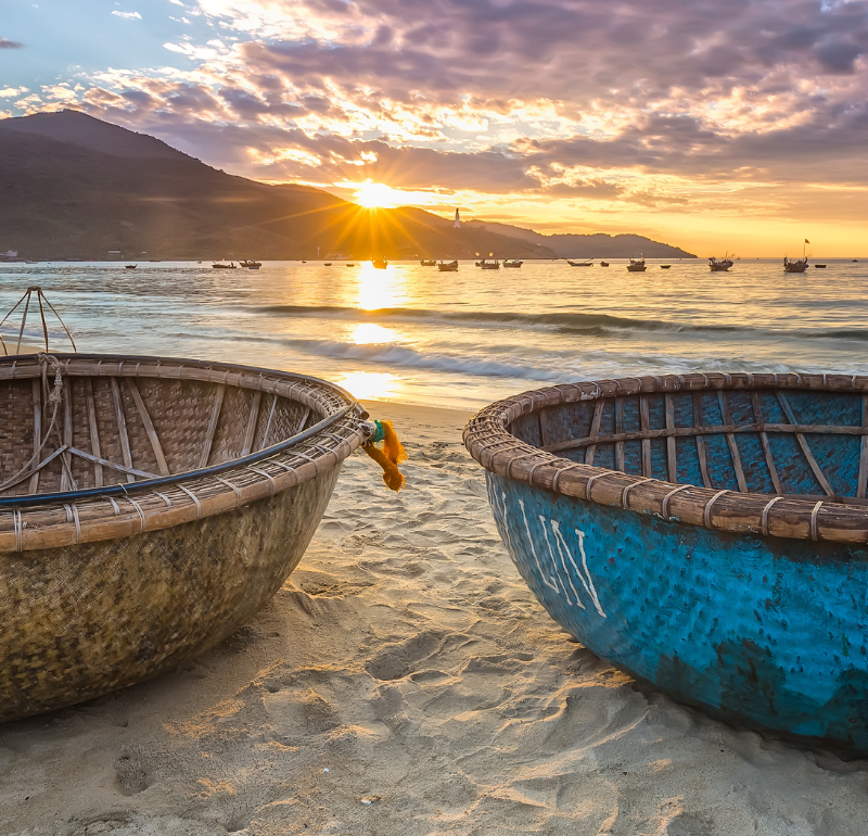 Two baskets on beach with water in the background.