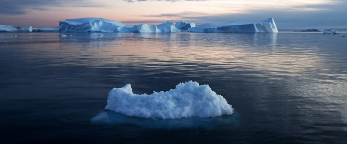 Small iceberg floats on dark ocean water.